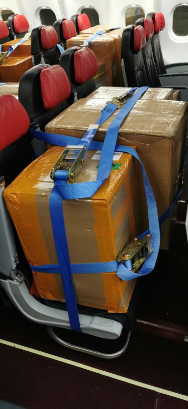 Boxes on aircraft seat with strap